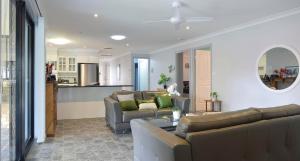 a living room with two couches and a kitchen at Cozy on north in Armidale