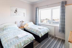 due letti in una stanza con finestra di Woolacombe Beach Retreat Apartments a Woolacombe Altre 21 foto