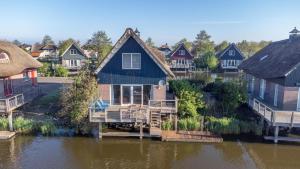 a house in the middle of a body of water at Villa Seaview met Sauna in Makkum