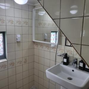 een badkamer met een wastafel en een spiegel bij Gwangan Beach Cozy House in Busan