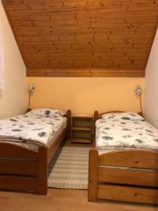 a bedroom with two beds and a wooden ceiling at Apartments Renata in Smoljanac