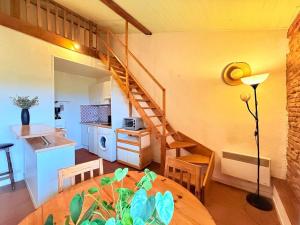 Villemur-sur-TarnにあるCocon paisible et confortable.のテーブルと階段のあるリビングルーム