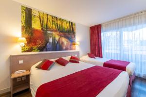 Postel nebo postele na pokoji v ubytování Logis Hotel Arc En Ciel