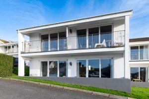 una casa bianca con un balcone di Woolacombe Beach Retreat Apartments a Woolacombe