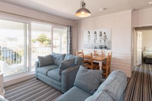 un soggiorno con due divani e una sala da pranzo con un tavolo di Woolacombe Beach Retreat Apartments a Woolacombe