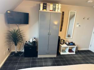a room with a tall cabinet with a tv on a wall at The Gables Whisky B&B in Dufftown