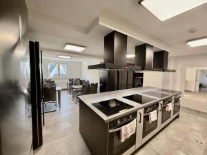 a kitchen with a stove and a dining room at Boardinghouse Zur Rose in Leidersbach