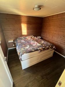 a bedroom with a bed in a wooden wall at Storklinten 119 in Boden +38 photos