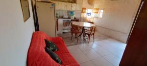a living room with a red couch and a kitchen at Casa en Parque Lago (Mar de Cobo) in Mar de Cobo +4 photos