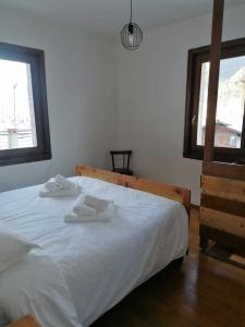 a bedroom with a white bed with two towels on it at GolfHouseApartment in Bocenago +1 photo