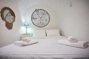 a bedroom with a white bed with towels on it at The Cocktail House- In the heart of the Island in Chios