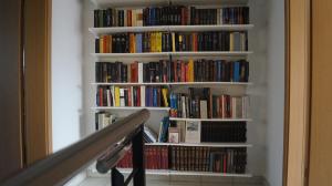 a book shelf filled with books next to a staircase at Casa Diana Ticino in Cugnasco