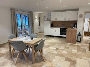 a kitchen and dining room with a table and chairs at Ferienwohnung Rinser 4 in Vogtareuth