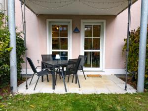 a black table and chairs in front of a pink house at Moderne Ferienwohnung in ruhiger idyllischer Lage 2 plus 2 Personen möglich in Plauen +1 photo