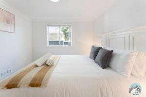 a large white bed in a white room at Aircabin - Colyton - Modern - 2-Bed Granny Flat in Colyton