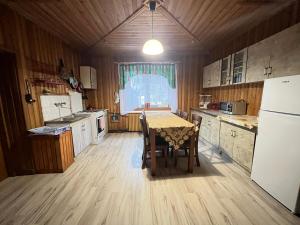 a kitchen with a table and chairs and a refrigerator at Pokoje u Cekusa in Białka Tatrzanska