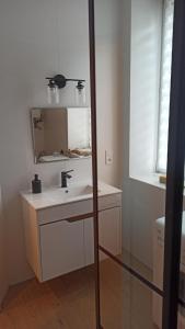 a white bathroom with a sink and a mirror at Studio Żdanowska Zamość in Zamość
