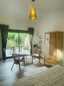a living room with a bed and a table and chairs at INSTANT ZEN in Saint-Vivien-de-Médoc