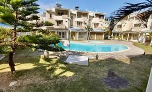 un complexe d'appartements avec une piscine et un bâtiment dans l'établissement Sea La Vie Villa, à Grand Gaube