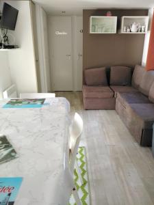 a living room with a table and a couch at Mobil home 6 à 8pers in Saint-Jean-de-Monts