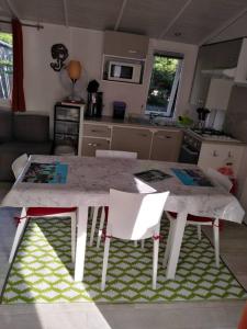 a kitchen with a table and chairs in a kitchen at Mobil home 6 à 8pers in Saint-Jean-de-Monts