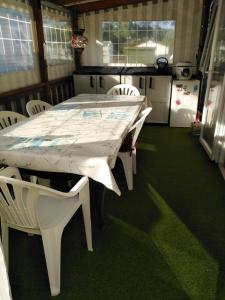 a white table and white chairs in a kitchen at Mobil home 6 à 8pers in Saint-Jean-de-Monts +2 photos