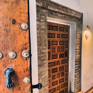a wooden door in a room with a stone wall at La casa grande in Carmona