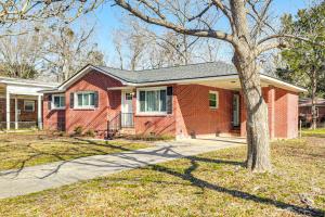 a red brick house with a tree in the yard at Conveniently Located North Charleston Home! in Charleston