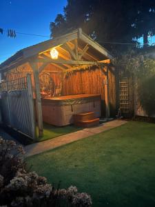 a gazebo with a bench in a yard at Acorn Cottage in Ollerton