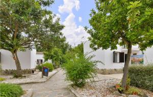 a walkway with trees in front of a white building at Con buen sabor Via verde, Antigua Estación Via verde de la sierra in Puerto Serrano
