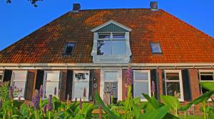 um edifício com um telhado laranja e uma janela em B&B Welgelegen em Workum