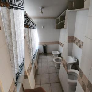 a bathroom with two toilets and two sinks at Rincon del Sur in Esquel