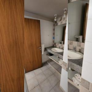 a bathroom with two sinks and a wooden door at Rincon del Sur in Esquel