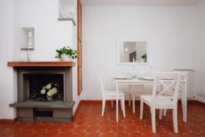 a white dining room with a table and a fireplace at Roma, Mare e Relax in Marina di Cerveteri
