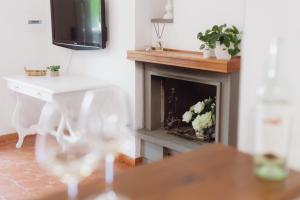 a living room with a fireplace and a table with wine glasses at Roma, Mare e Relax in Marina di Cerveteri