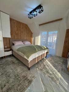 a bedroom with a bed and a large window at Crown Apartmani Vlašić in Vlasic