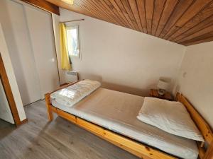 a bedroom with a bed with a wooden ceiling at Maison abelias soustons plage in Soustons