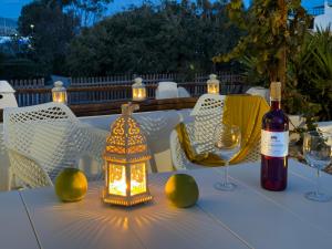 a table with a bottle of wine and a lantern at ANETON Residences in Karavostasi