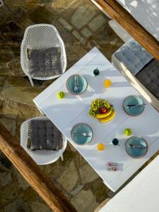 an overhead view of a white table with dishes and a chair at ANETON Residences in Karavostasi