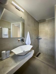 a bathroom with a sink and a mirror at ANETON Residences in Karavostasi