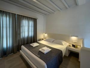 a bedroom with a bed with two towels on it at ANETON Residences in Karavostasi