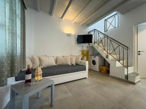 a living room with a couch and a staircase at ANETON Residences in Karavostasi