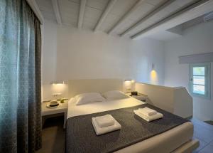 a bedroom with a bed with two towels on it at ANETON Residences in Karavostasi
