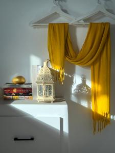 a room with a yellow curtain and some books at ANETON Residences in Karavostasi