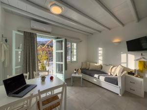 a bedroom with a bed and a desk with a laptop at ANETON Residences in Karavostasi