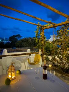 a table with a bottle of wine and two glasses at ANETON Residences in Karavostasi