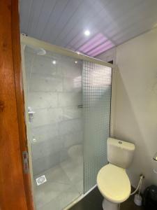 a bathroom with a toilet and a glass shower at Estudio Aconchegante no Sul da Ilha in Florianópolis +24 photos