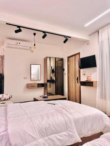 a bedroom with a large white bed and a mirror at Akasia Pyramids View in Cairo