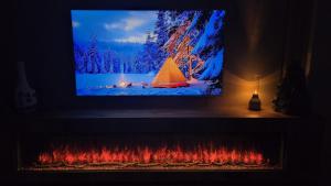 a tv screen with a picture of a fire place at Snow Leopard Residence in Osh