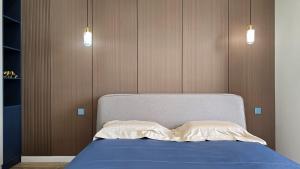 a bedroom with a bed with blue sheets and wooden walls at Snow Leopard Residence in Osh